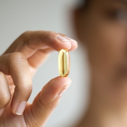 Woman holding one liquid capsule